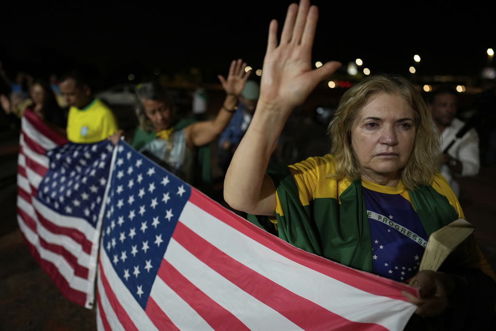 Supporters of Brazil's former President Jair Bolsonaro pray during a vigil in his support near his home where he is under house arrest, in Brasilia, Brazil, Thursday, Sept. 11, 2025. (AP Photo/Eraldo Peres)