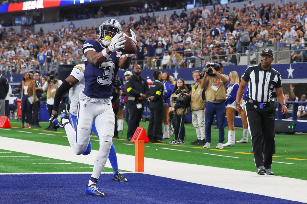 Dallas Cowboys wide receiver George Pickens (3) makes a touchdown catch past Los Angeles Chargers cornerback Cam Hart (20) during the first half of an NFL football game Sunday, Dec. 21, 2025, in Arlington, Texas (AP Photo/Richard W. Rodriguez)