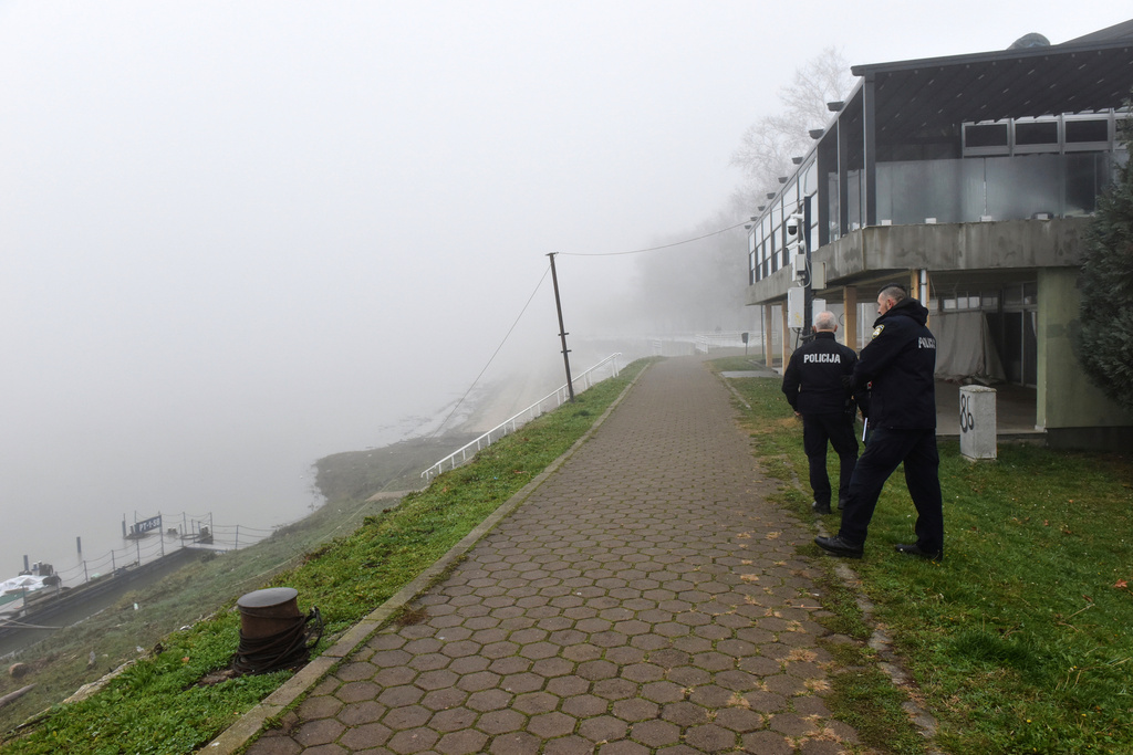 Croatian police officers look from the shore of Sava river near the site where a boat carrying migrants from Bosnia overturned in eastern Croatia, in Slavonski Brod, Thursday, Dec. 11, 2025. (AP Photo/Nenad Opacak)