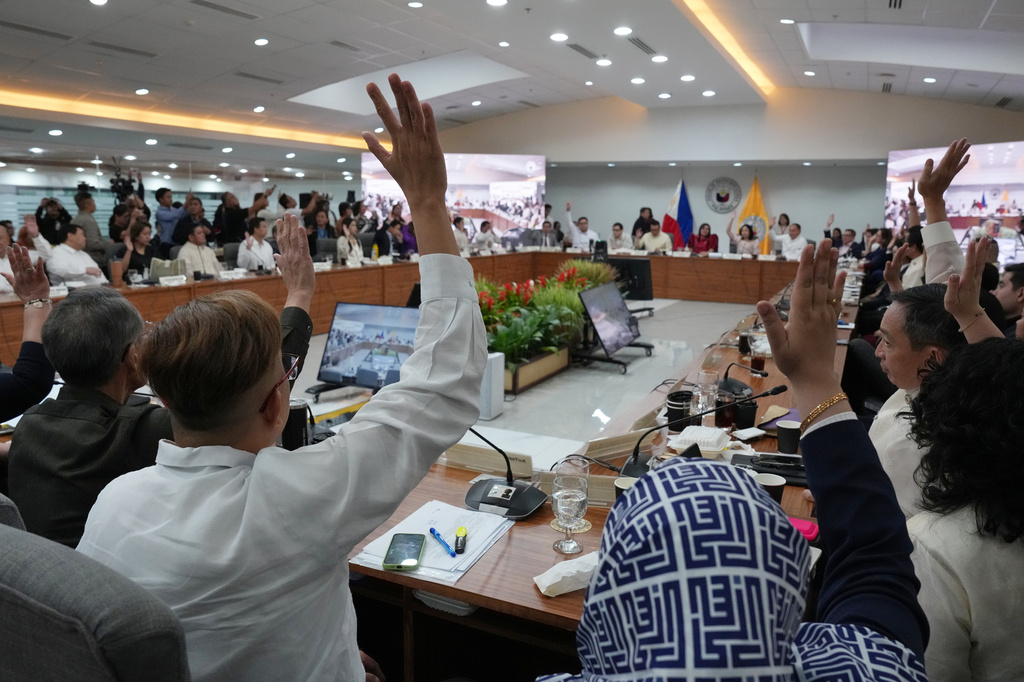 Members of Congress justice committee raise their hands as they vote during a congressional hearing on an impeachment bid against Vice President Sara Duterte at the House of Representatives in Quezon, Philippines Wednesday, April 29, 2026. (AP Photo/Aaron Favila)