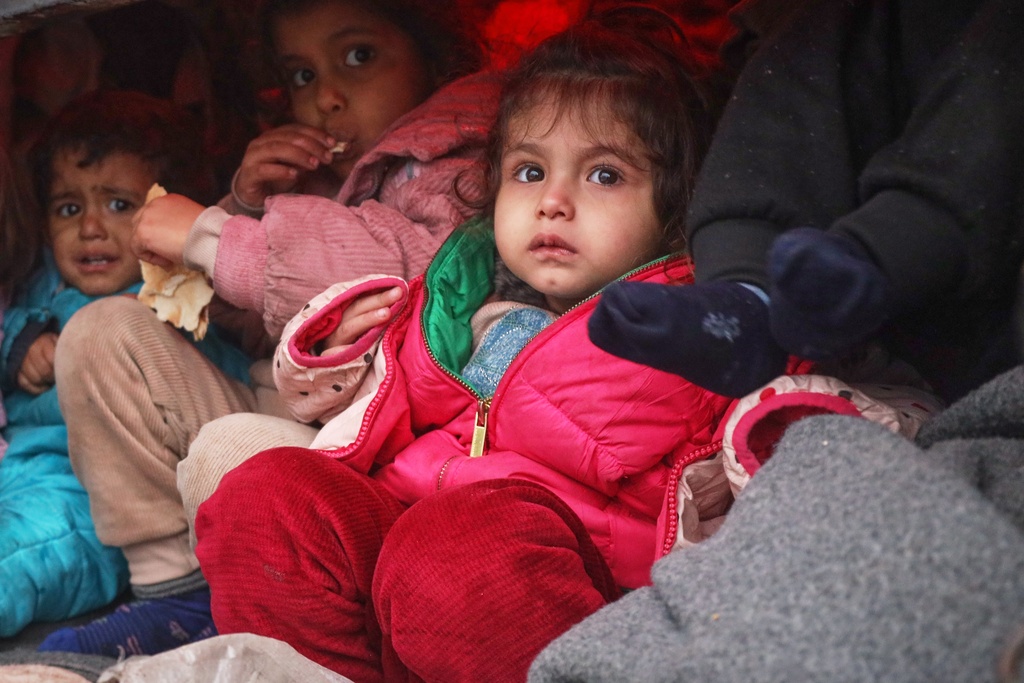 Children from Syrian Kurdish families displaced amid the ongoing battle between government forces and the Syrian Democratic Forces (SDF) arrive in Qamishli, northeastern Syria, Sunday, Jan. 18, 2026.(AP Photo/Baderkhan Ahmad)