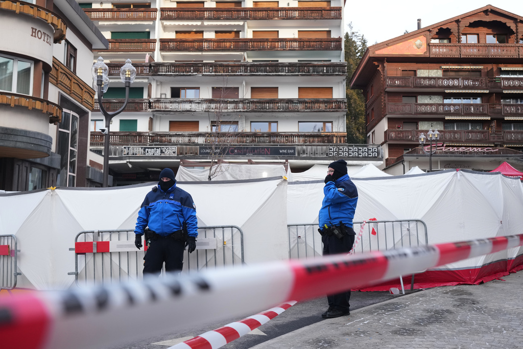Security stands in front of the sealed off Le Constellation bar, where a devastating fire left dead and injured during the New Year's celebrations in Crans-Montana, Swiss Alps, Switzerland, Friday morning, Jan. 2, 2026. (AP Photo/ Antonio Calanni)