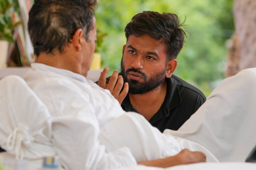 Abhijeet Dipke, founder of the Cockroach Janta Party, center, talks to climate activist Sonam Wangchuk, who is undertaking an indefinite hunger strike during a protest demanding the resignation of Education Minister Dharmendra Pradhan over alleged examination irregularities and repeated paper leaks in New Delhi, India, on July 10, 2026. (AP Photo/Manish Swarup)