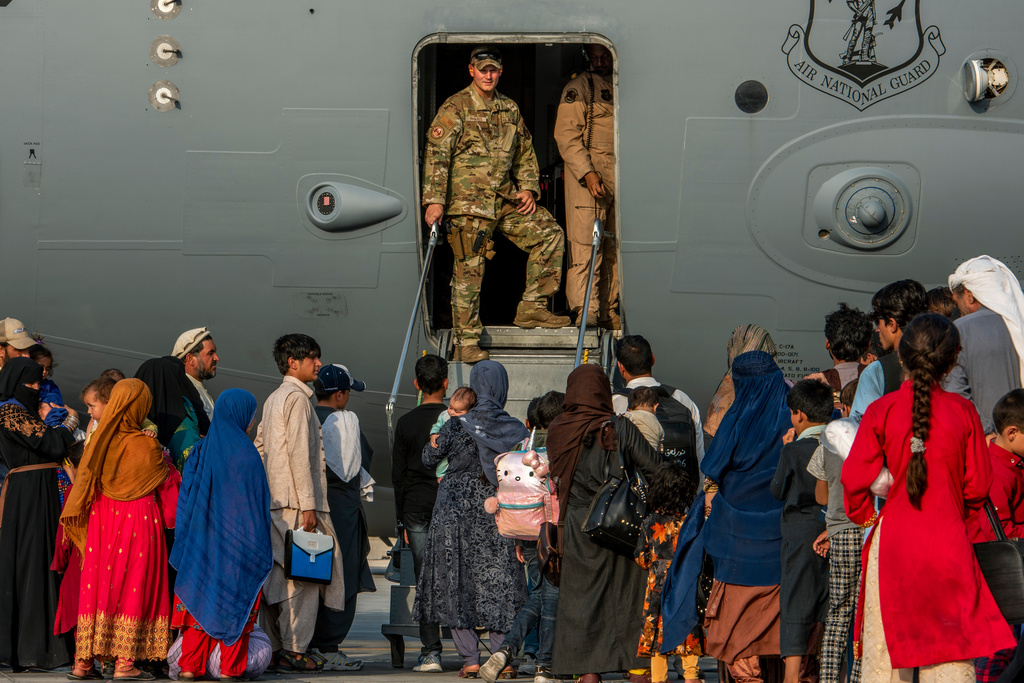 FILE - In this Aug. 22, 2021 file photo provided by the U.S. Air Force, service members stand at a doorway as Afghan evacuees prepare to board an aircraft, Aug. 22, 2021, at Al Udeid Air Base, Qatar. (Airman 1st Class Kylie Barrow/U.S. Air Force via AP, File)