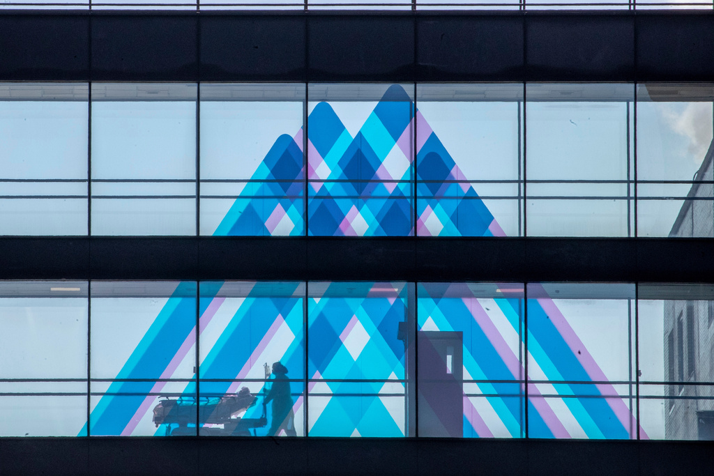 FILE - A medical worker transports a patient at Mount Sinai Hospital, April 1, 2020, in New York. (AP Photo/Mary Altaffer, File)