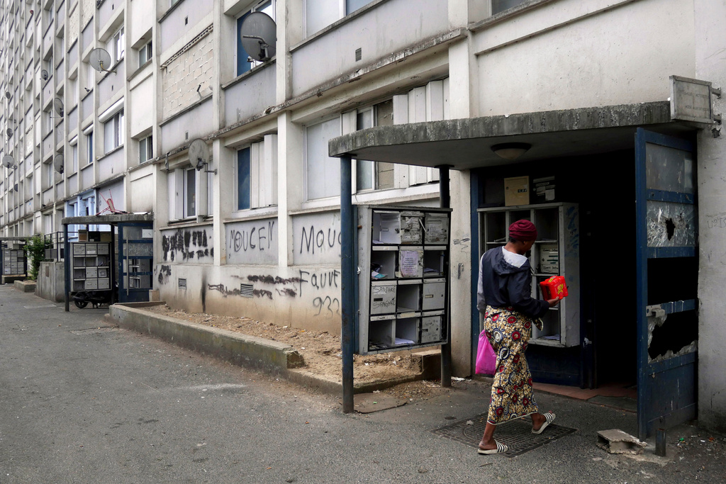 FILE - A woman goes home with a meal distributed by 'Laissez Les Servir' (Let Them Serve) in the Fauvettes projects, Pierrefitte-sur-Seine, north of Paris, Thursday, April 29, 2021. (AP Photo/Thibault Camus, File)