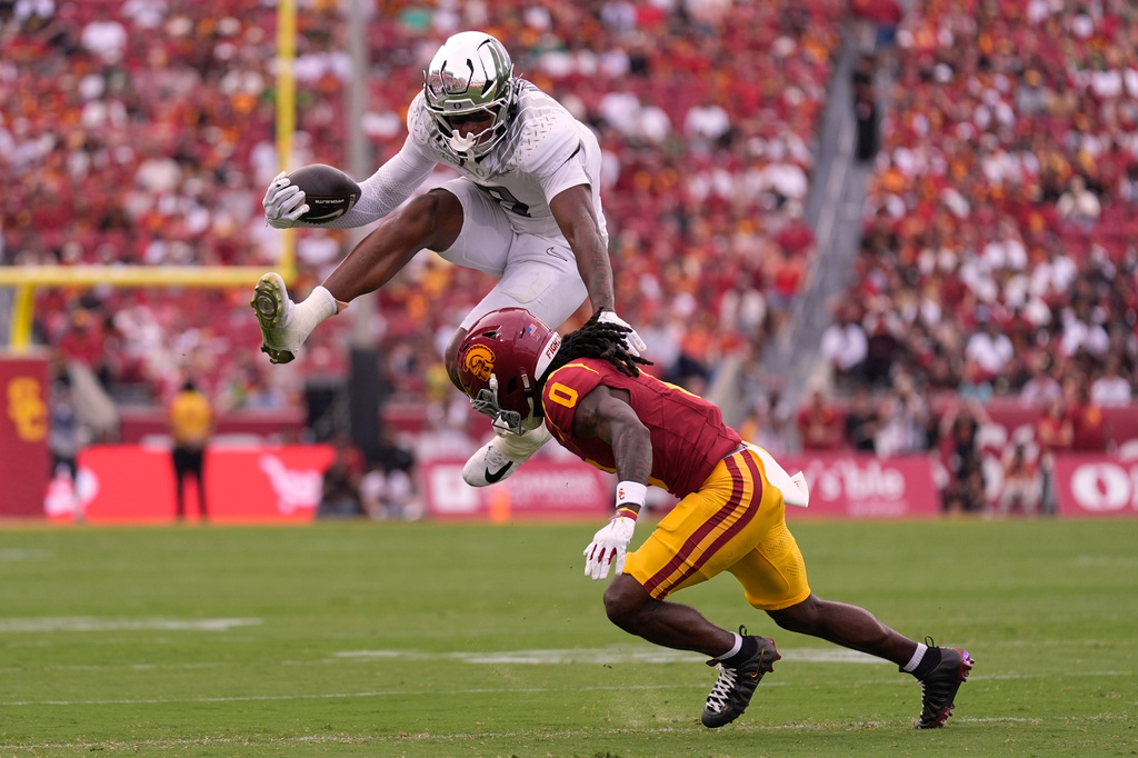 Oregon tight end Jamari Johnson, top, jumps over Southern California cornerback Jontez Williams during the first half of an NCAA college football game, Saturday, Sept. 26, 2026, in Los Angeles. (AP Photo/Mark J. Terrill)