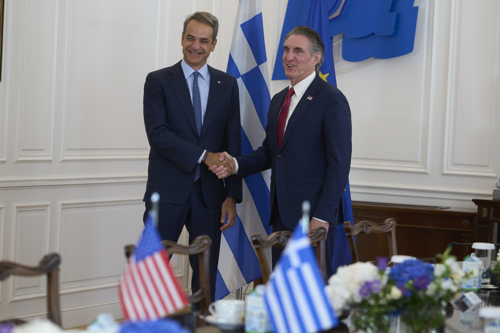 Greek Prime Minister Kyriakos Mitsotakis, left, shakes hands with U.S. Secretary of the Interior Doug Burgum, during their meeting at the Maximou Mansion in Athens, Thursday, Sept. 11, 2025. (AP Photo/Petros Giannakouris)