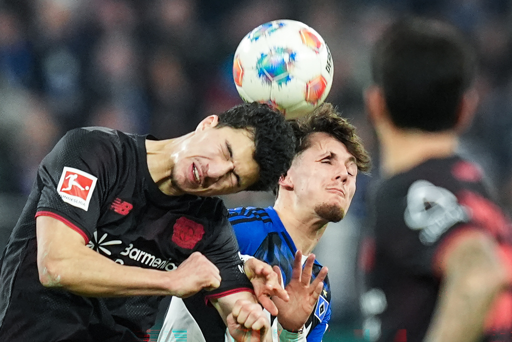 Leverkusen's Ibrahim Maza, left, and Hamburger's Otto Stange fight for the ball during the Bundesliga soccer match between Hamburger SV and Bayer Leverkusen, in Hamburg, Germany, Wednesday March 4, 2026. (Marcus Brandt/dpa via AP)