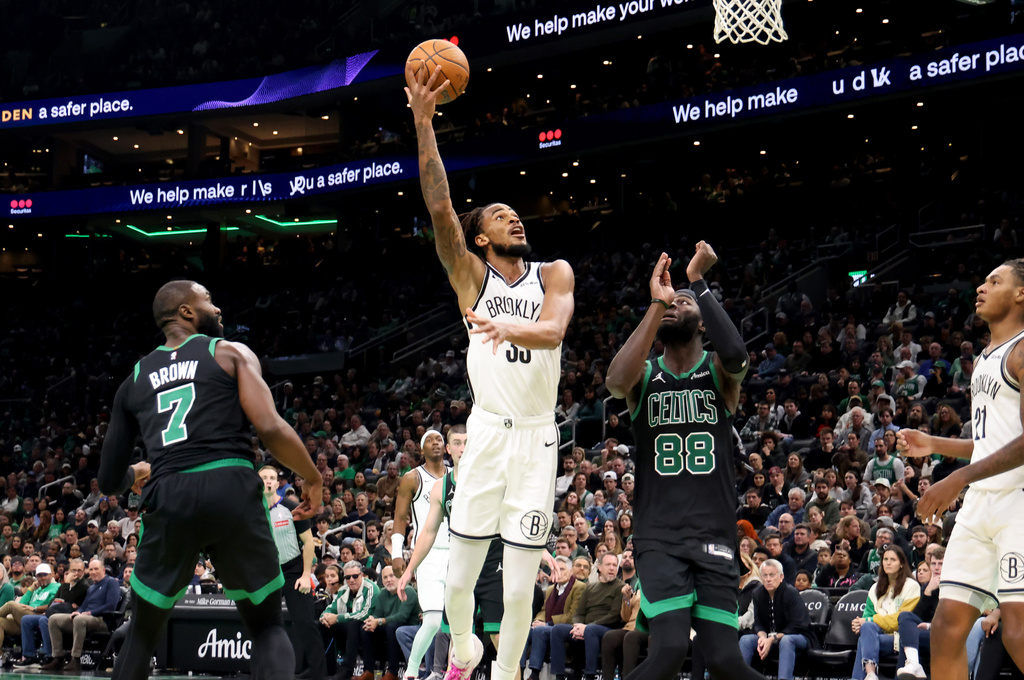 Brooklyn Nets center Nic Claxton (33) scores next to Boston Celtics forward Jaylen Brown (7) and Boston Celtics center Neemias Queta (88) during the second half of an NBA Cup basketball game, Friday, Nov. 21, 2025, in Boston. (AP Photo/Mark Stockwell)