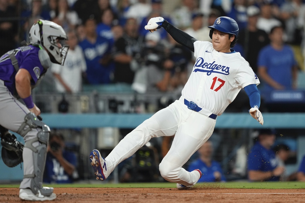 Los Angeles Dodgers' Shohei Ohtani, left, scores on a double by Mookie Betts as Colorado Rockies catcher Braxton Fulford waits for the ball during the second inning of a baseball game Wednesday, Sept. 10, 2025, in Los Angeles. (AP Photo/Mark J. Terrill)