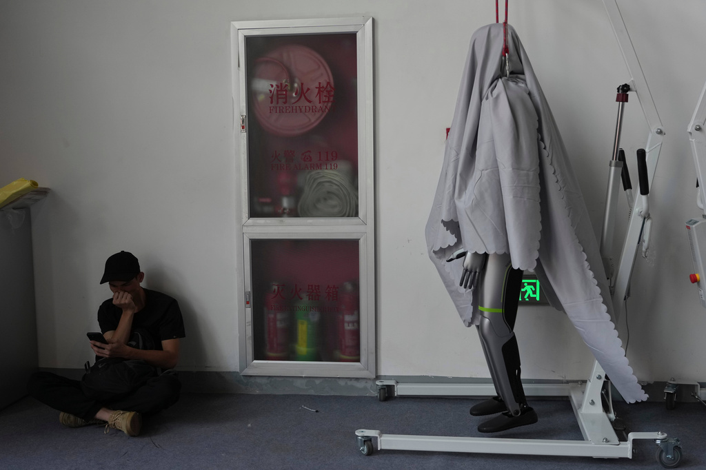 A robot is shrouded in-between performances during Auto China 2026 in Beijing, Saturday, April 25, 2026. (AP Photo/Ng Han Guan)