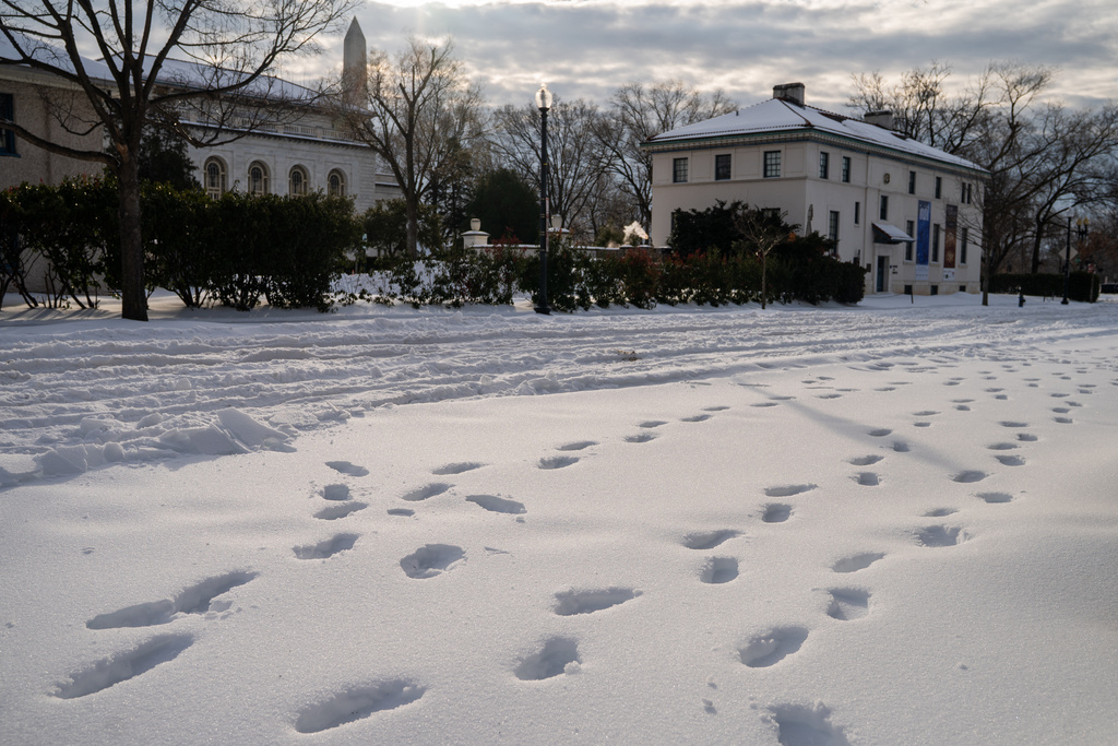 Footprints mark the snow in Washington, Monday, Jan. 26, 2026. (AP Photo/Allison Robbert)
