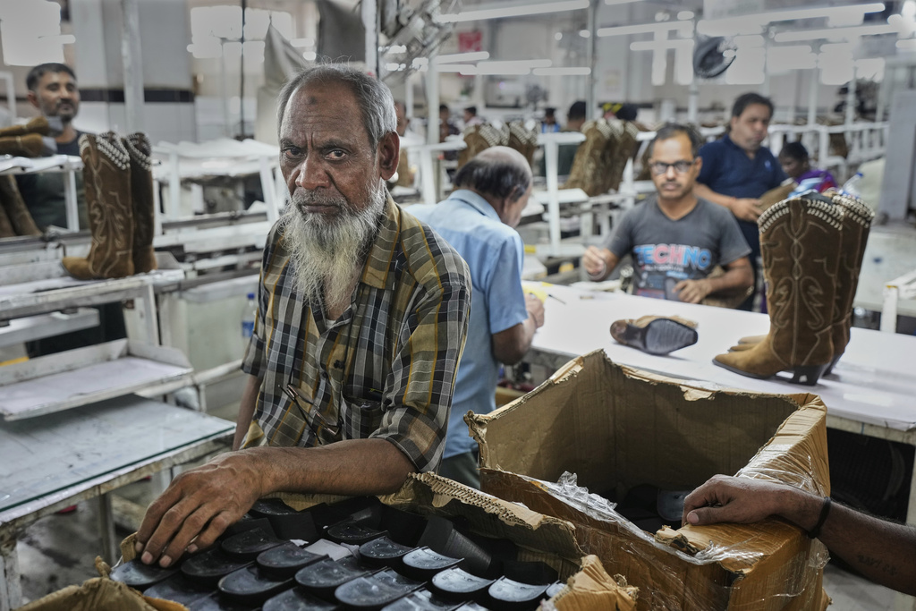 Workers at a manufacturing unit make leather footwear in Agra, India, Monday, Aug. 25, 2025. (AP Photo/Manish Swarup)