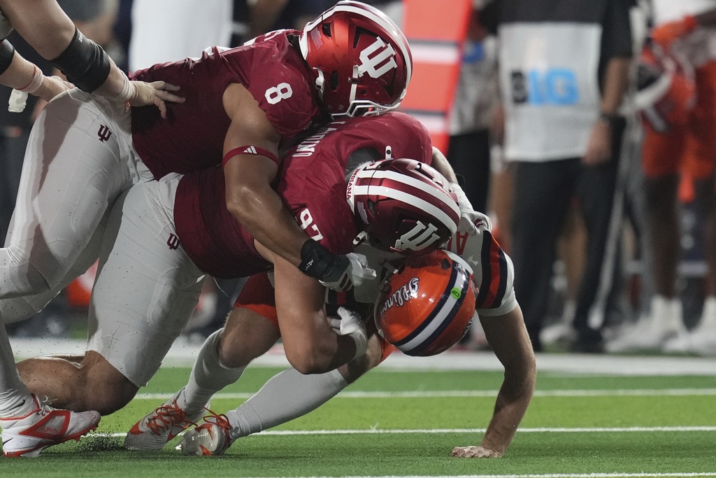 Illinois quarterback Luke Altmyer (9) is sacked by Indiana defensive lineman Stephen Daley (8)and defensive lineman Mario Landino (97) during the first half of an NCAA college football game, Saturday, Sept. 20, 2025, in Bloomington, Ind. (AP Photo/Darron Cummings)