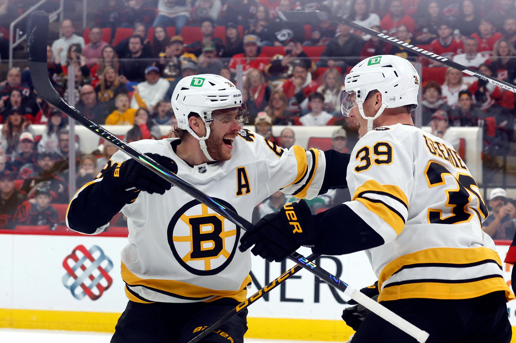 Boston Bruins' David Pastrnak (88) congratulates teammate Morgan Geekie (39) on his goal during the first period of an NHL hockey game against the Carolina Hurricanes in Raleigh, N.C., Tuesday, April 7, 2026. (AP Photo/Karl DeBlaker)