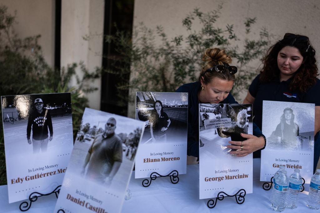 Savannah Sampson, right, and Nicole Lewis, help set up a vigil for the victims of Tuesday's fatal SUV-Metro bus collision and the subsequent crash of a TV news helicopter that was covering it in the Chatsworth neighborhood of Los Angeles, Thursday, Sept. 17, 2026. (AP Photo/Jae C. Hong)