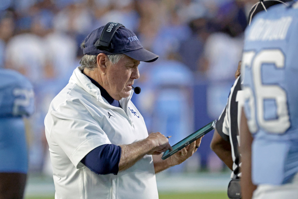 North Carolina head coach Bill Belichick checks his tablet during a break in the action during the first half of an NCAA college football game against Stanford, Saturday, Nov. 8, 2025, in Chapel Hill, N.C. (AP Photo/Chris Seward)
