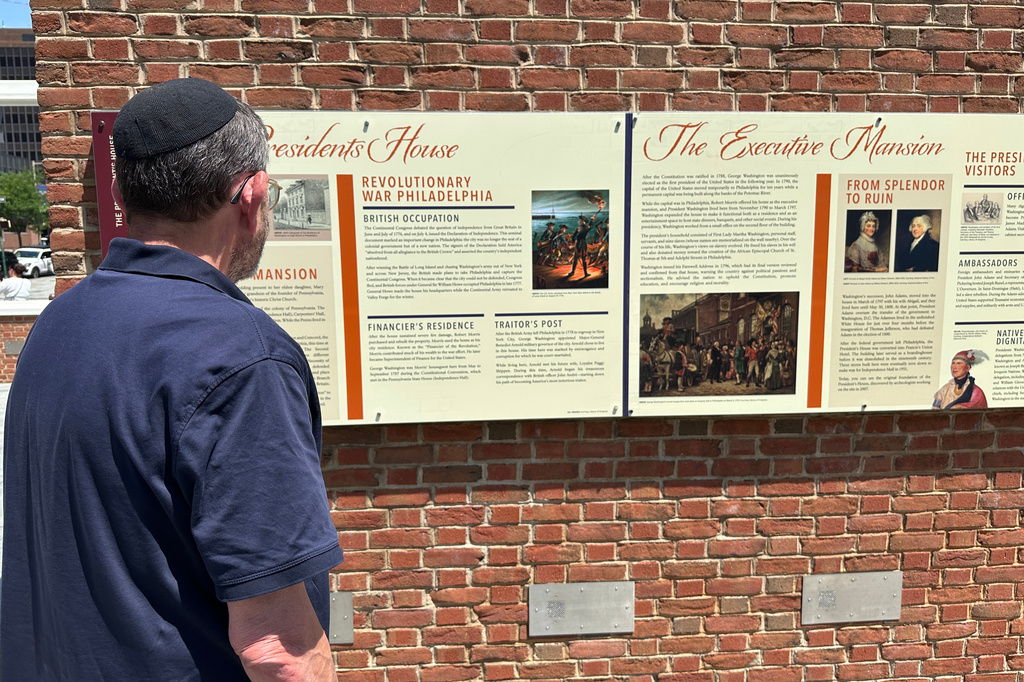 Visitors view the reinstalled educational panels about slavery at the site of President George Washington's home in Philadelphia, Wednesday, July 15, 2026. (AP Photo/Tassanee Vejpongsa)