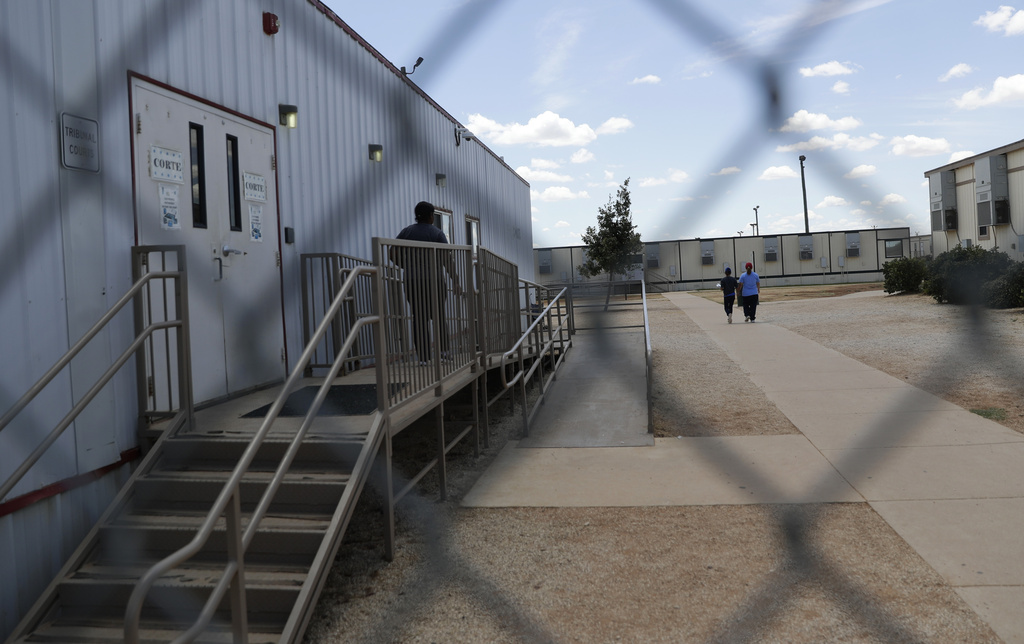 FILE - Immigrants seeking asylum walk at the ICE South Texas Family Residential Center, on Aug. 23, 2019, in Dilley, Texas. (AP Photo/Eric Gay, File)