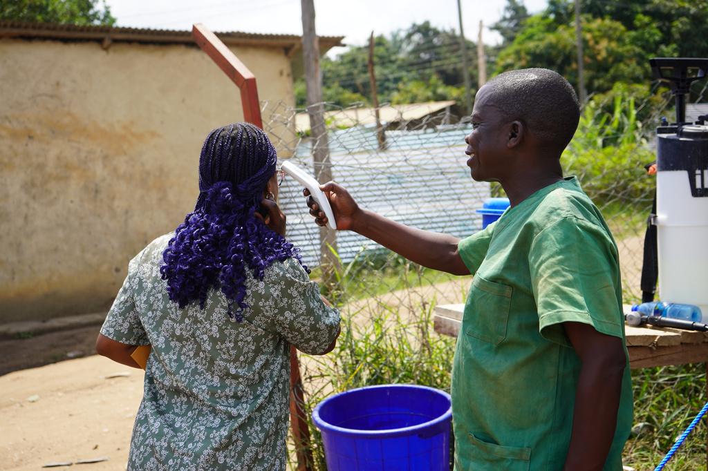 A health worker checks the temperature of a woman at the ebola treatment centre in Bunia, Congo, Monday, July 20, 2026. (AP Photo/Prosper Heri Ngorora)