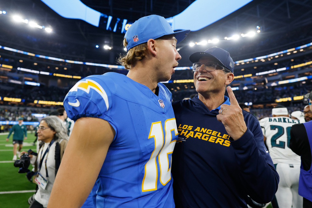 Los Angeles Chargers head coach Jim Harbaugh celebrates with J.K. Scott after a win over the Philadelphia Eagles in an NFL football game Monday, Dec. 8, 2025, in Inglewood, Calif. (AP Photo/Caroline Brehman)