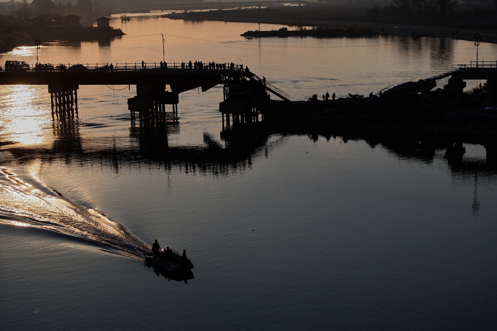 People cross a damaged bridge over the Euphrates River in Raqqa, Syria, Sunday, Jan. 25, 2026. (AP Photo/Ghaith Alsayed)