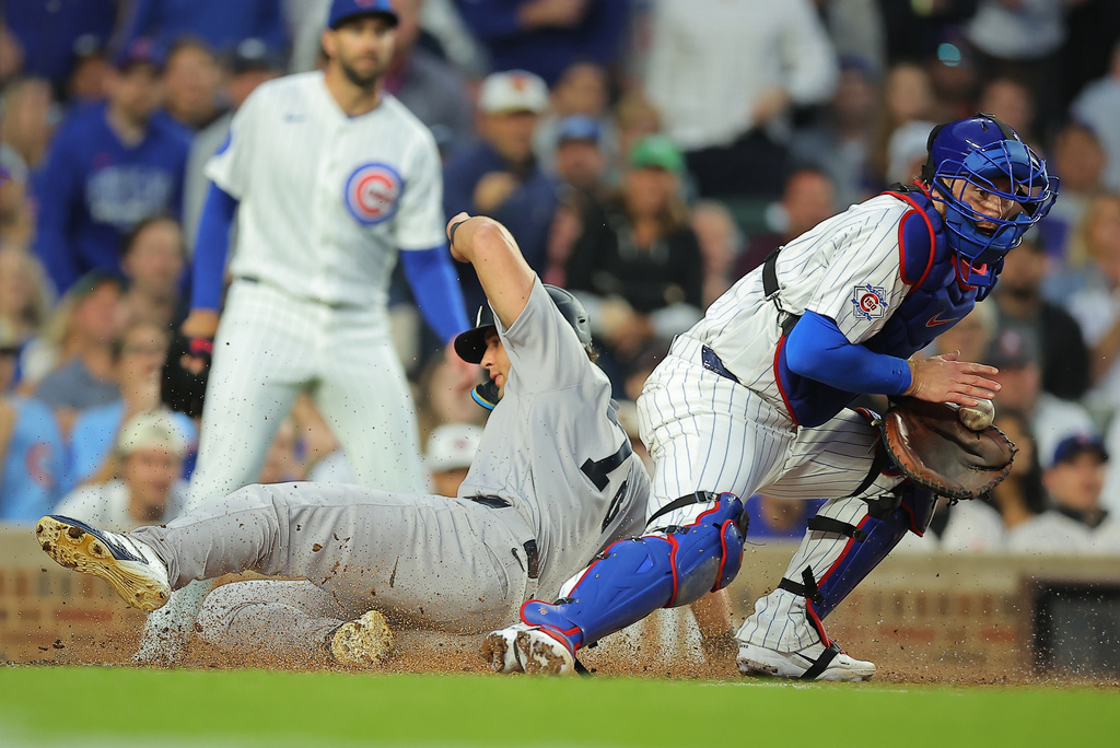 New York Yankees' Spencer Jones slides into home plate on New York Yankees' José Caballero's RBI single during the fifth inning of a baseball game against the Chicago Cubs, Saturday, Aug. 1, 2026, in Chicago. (AP Photo/Melissa Tamez)