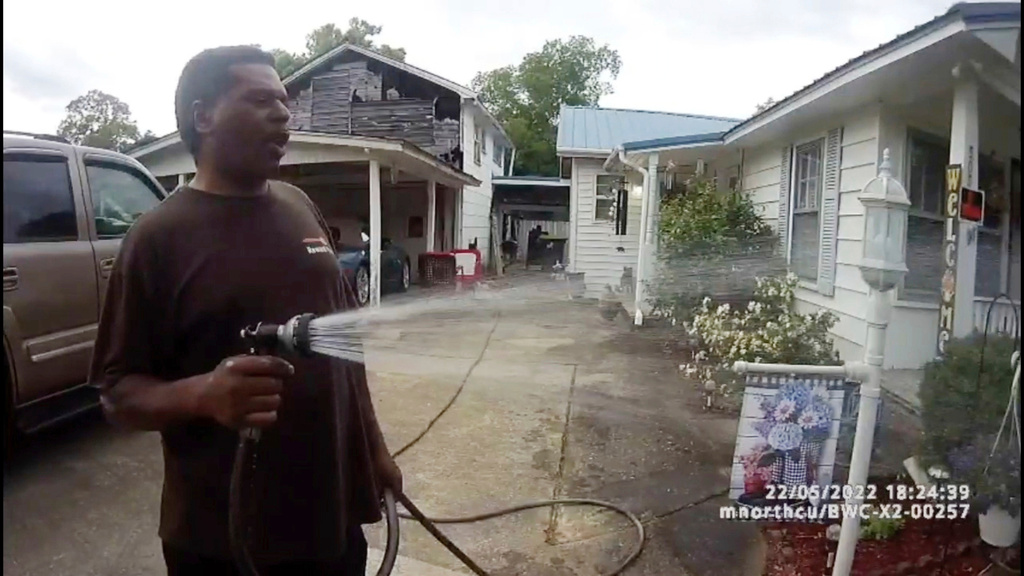 FILE - This image made from bodycamera video released by the Childersburg (Ala.) Police Department and provided by attorney Harry Daniels shows Michael Jennings, left, watering flowers in Childersburg, Ala., May 22, 2022. (Childersburg Police Department via AP, File)