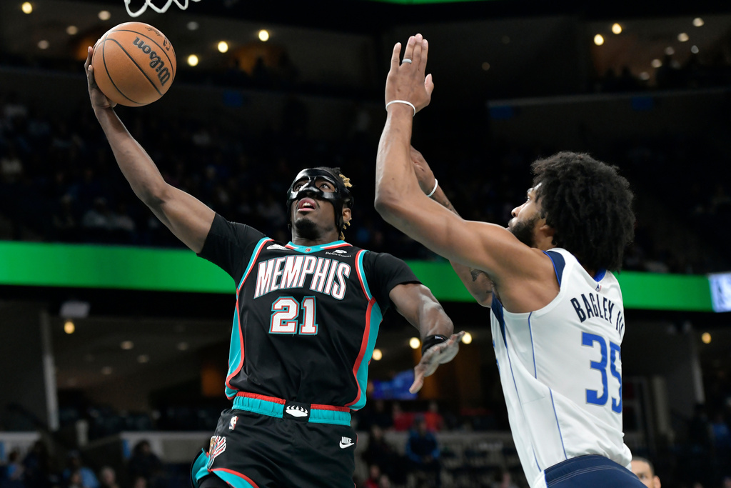 Memphis Grizzlies guard Jahmai Mashack (21) shoots against Dallas Mavericks forward Marvin Bagley III (35) in the first half of an NBA basketball game Thursday, March 12, 2026, in Memphis, Tenn. (AP Photo/Brandon Dill)