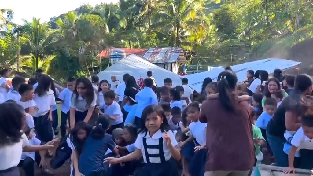This image made from video provided by DepEd Mahayahay Elementary School shows school children reacting as a canopy roof, rear, collapsed, caused by a powerful earthquake Monday, June 8, 2026, in Malita, Davao Occidental Province, Philippines. (DepEd Mahayahay Elementary School via AP)