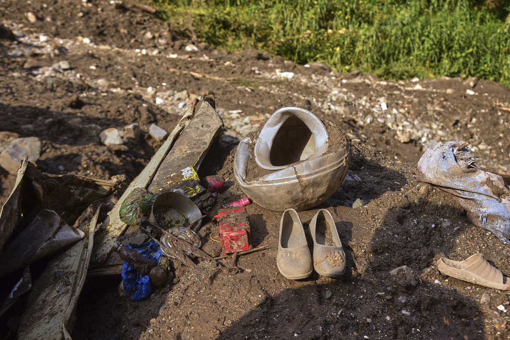 Shoes and other household items are seen in the debris of damaged houses at the site of a cloudburst that triggered flash floods, in Naryan Behak village near Muzaffarabad, the main town of Pakistan's controlled Kashmir, Friday, Aug. 15, 2025. (AP Photo/M.D. Mughal)