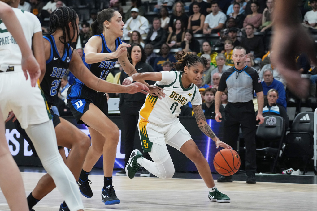 Baylor guard Taliah Scott (0) drives on Duke forward Jordan Wood (13) in the first half of an NCAA college basketball game Monday, Nov. 3, 2025 in Paris. (AP Photo/Thibault Camus)