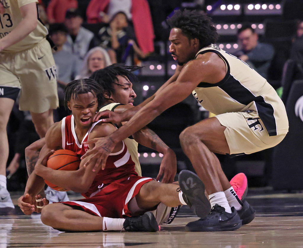 Stanford's Ebuka Okorie (1) battles for a loose ball with Wake Forest's Juke Harris (2) and Wake Forest's Mekhi Mason, right, during an NCAA college basketball game on Saturday, Feb. 14, 2026, in Winston-Salem, N.C. (Walt Unks/The Winston-Salem Journal via AP)