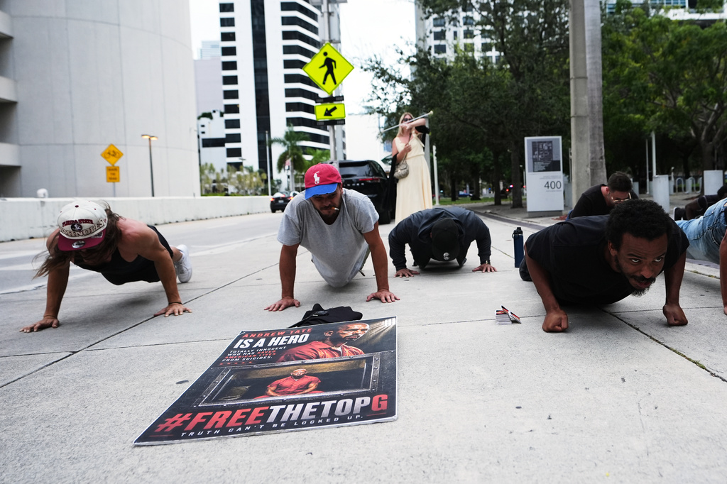 Supporters of Andrew and Tristan Tate do push-ups outside of the C. Clyde Atkins U.S. Courthouse as the Tate brothers fight extradition to the United Kingdom on charges of rape and sex trafficking in Miami, Thursday, Aug. 27, 2026. (AP Photo/Lynne Sladky)