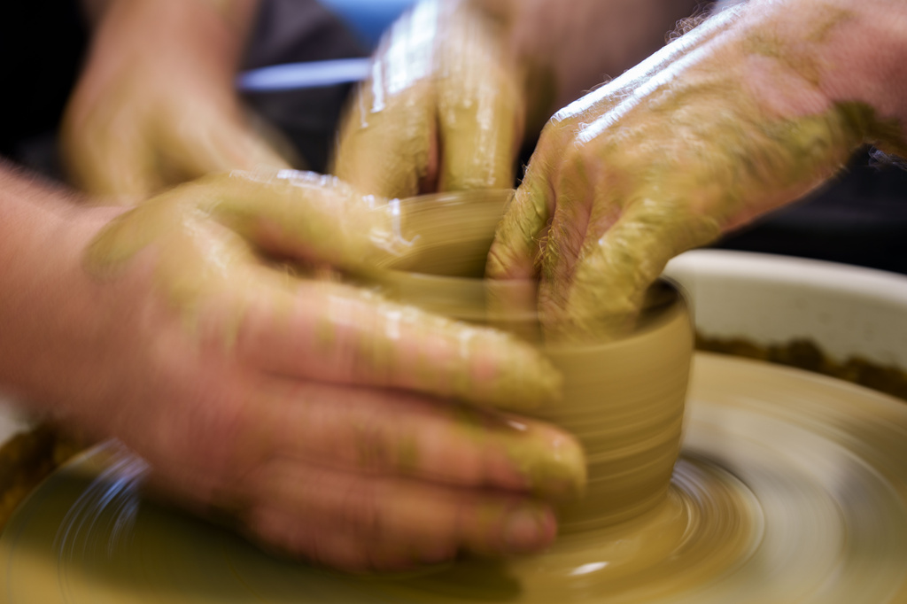 Ivan Shostak, a blind Ukrainian war veteran trains his blind comrade Viacheslav Sadovskyi to make a clay plate on a pottery wheel in a workshop at a rehabilitation center in Vinnytsia, Ukraine, on May 21, 2026. (AP Photo/Evgeniy Maloletka)