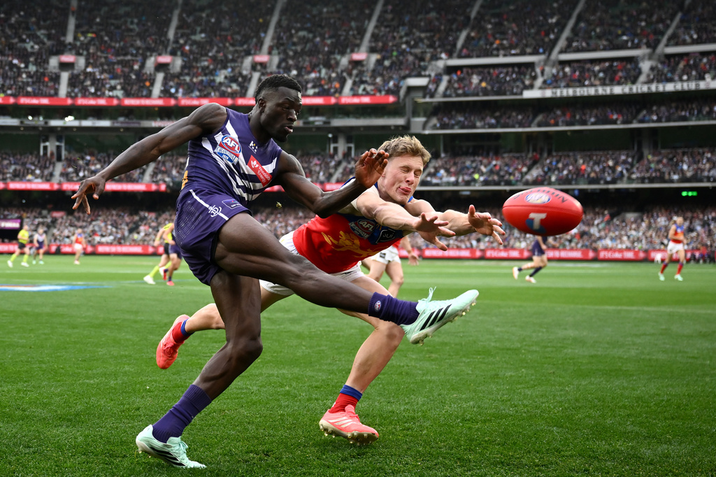 Jaspa Fletcher of the Brisbane Lions, right, attempts to smother a kick by Michael Frederick of the Fremantle Dockers during the Australian Football League grand final in Melbourne, Australia Saturday, Sept. 26, 2026. (Joel Carrett/AAP Image via AP)