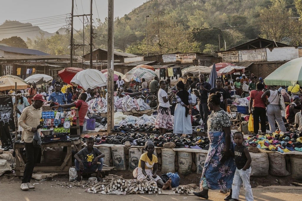 A woman and a child walk past a market in Zomba, Malawi, Wednesday, Sept. 10, 2025. (AP Photo/Thoko Chikondi)