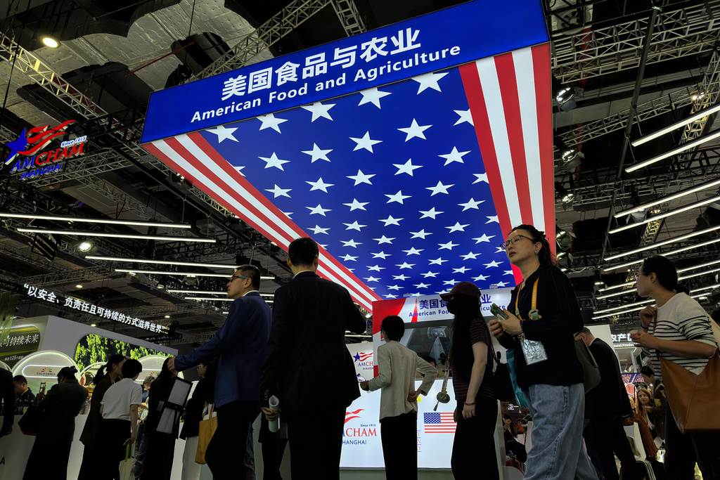 Visitors tour past the exhibition booth of American Food and Agriculture during the China International Import Expo, in Shanghai, China, Thursday, Nov. 6, 2025. (AP Photo/Wayne Zhang)
