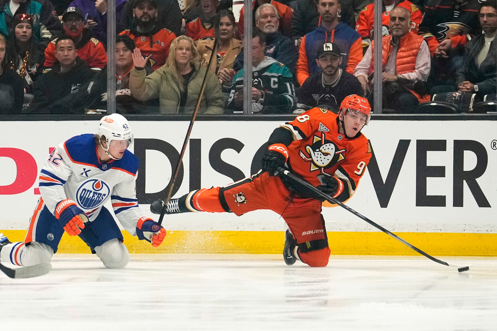 Anaheim Ducks defenseman Pavel Mintyukov, right, falls as he passes the puck while under pressure from Edmonton Oilers right wing Kasperi Kapanen during the first period of Game 3 in the first round of the NHL hockey Stanley Cup playoffs Friday, April 24, 2026, in Anaheim, Calif. (AP Photo/Mark J. Terrill)