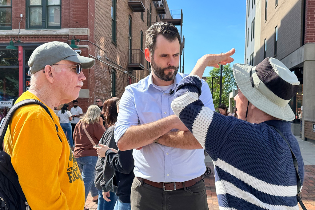 Iowa state Sen. Zach Wahls, a Democratic candidate for U.S. Senate, talks with voters in Des Moines, Iowa, Saturday, May 23, 2026. (AP Photo/Hannah Fingerhut)