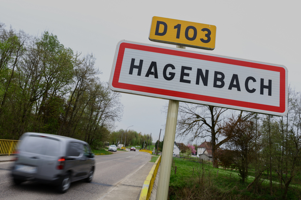 A car drives past a road sign at the entrance of Hagenbach where a 9-year-old boy was rescued this week after living locked in his father's utility van since 2024, Eastern France, Saturday, April 11, 2026. (AP Photo)