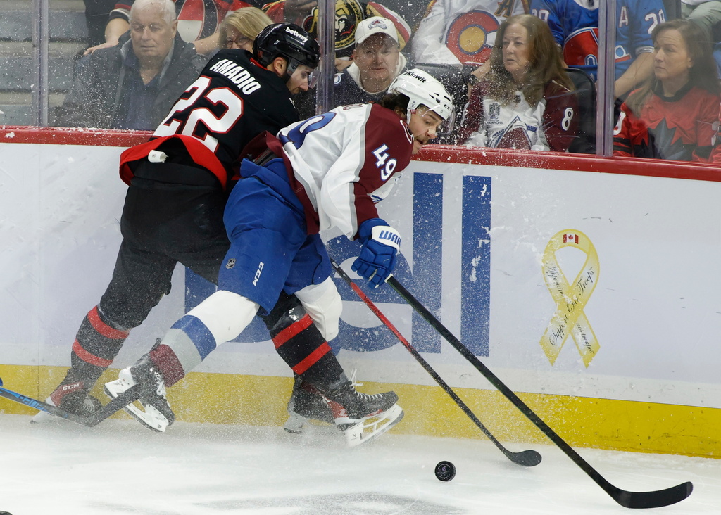 Ottawa Senators' Michael Amadio (22) and Colorado Avalanche's Samuel Girard (49) battle for the puck during the second period of an NHL hockey game in Ottawa, Ontario, on Wednesday, Jan. 28, 2026. (Patrick Doyle/The Canadian Press via AP)