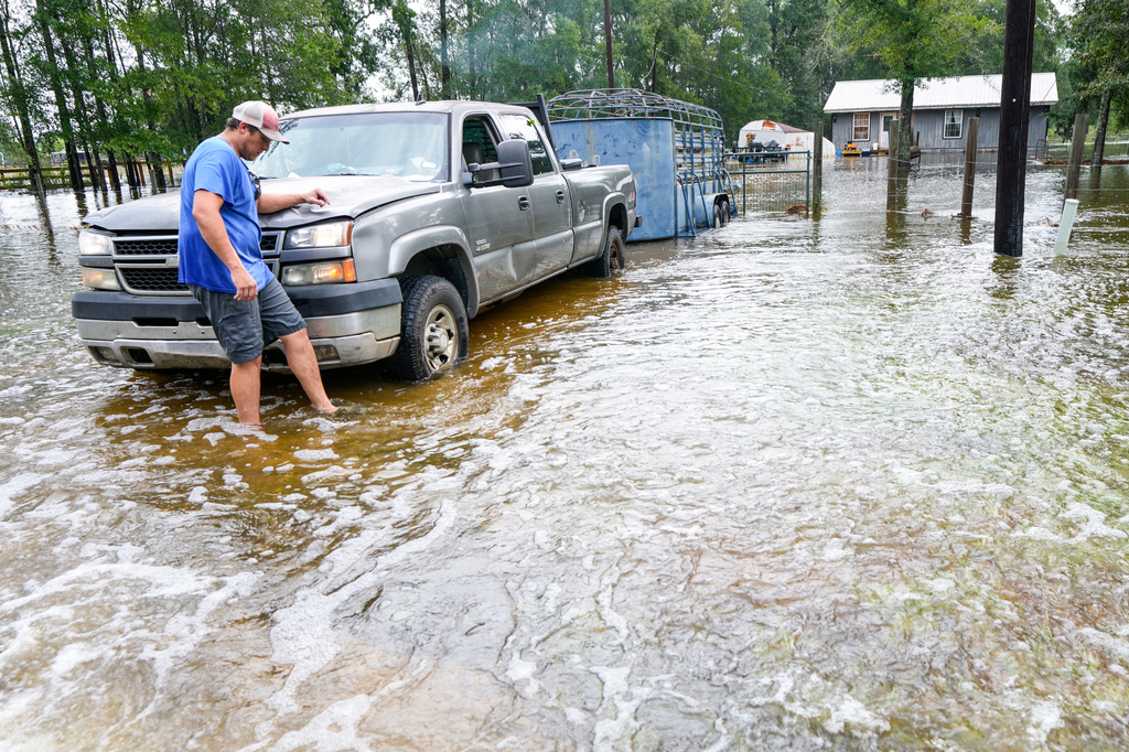 Chase Barfield walks to his truck as he takes belongings and his dogs away from floodwaters around his house in the aftermath of Tropical Storm Edouard near Honey Island, Texas, Wednesday, Sept. 2, 2026. (Brett Coomer/Houston Chronicle via AP)
