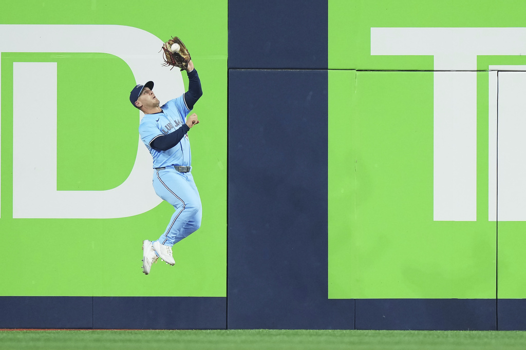 Toronto Blue Jays outfielder Daulton Varsho (5) makes a leaping catch against the Chicago Cubs during the fifth inning of a baseball game in Toronto on Wednesday, Aug. 13, 2025. (Nathan Denette/The Canadian Press via AP)