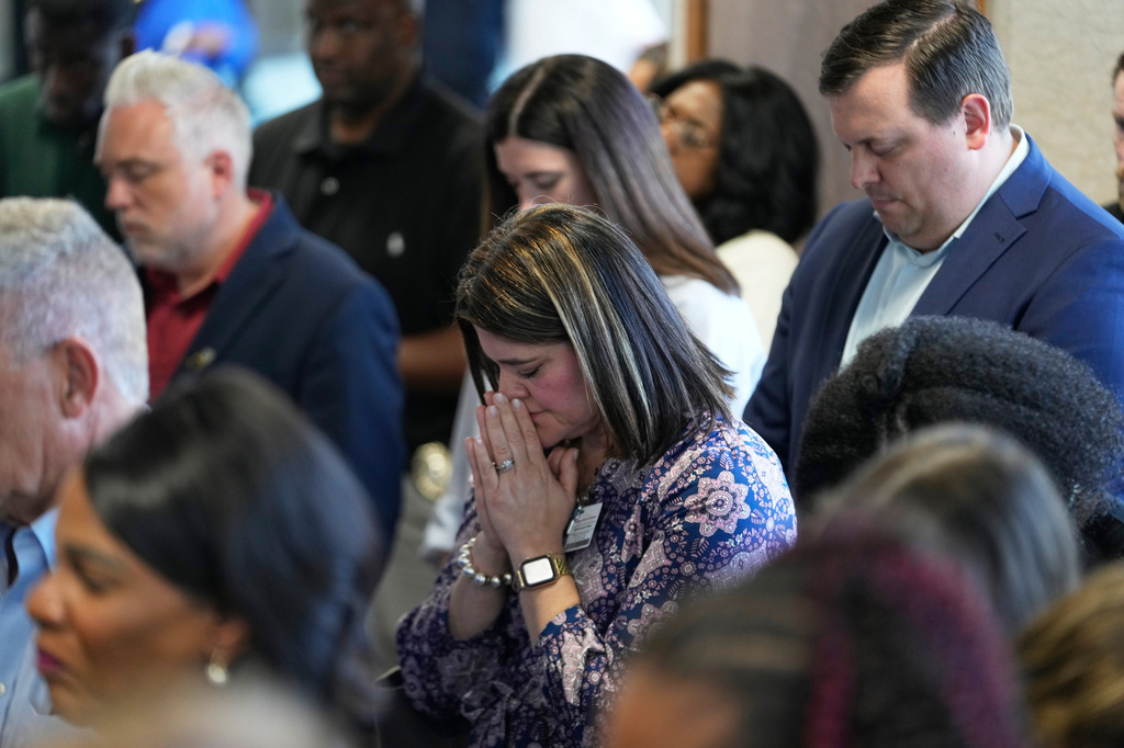 Attendees pray at the conclusion of a news conference about the children killed during a mass shooting the day before in Shreveport, La., Monday, April 20, 2026. (AP Photo/Gerald Herbert)