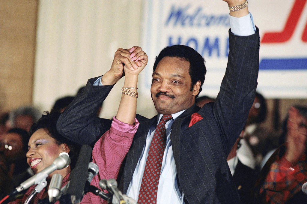 FILE - Democratic presidential hopeful Jesse Jackson with his wife, Jacqueline, salutes the cheering crowd at Operation Push in Chicago, March 10, 1988. (AP Photo/Fred Jewell, File)