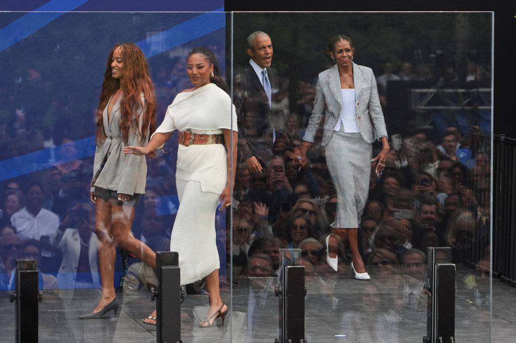 Former President Barack Obama, back center, and former first lady Michelle Obama, right, arrive on stage with their daughters, Sasha and Malia Obama, during the dedication ceremony for the Obama Presidential Center, Thursday, June 18, 2026, in Chicago. (AP Photo/Jeff Roberson)