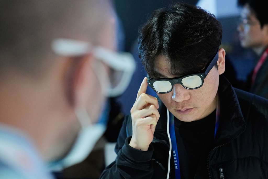 A person interacts with the RayNeo X3 Pro AI and AR glasses at the TCL booth during the CES tech show Wednesday, Jan. 7, 2026, in Las Vegas. (AP Photo/John Locher)