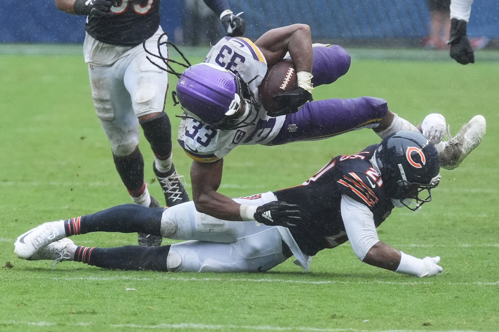 Minnesota Vikings running back Aaron Jones Sr. (33) runs as Chicago Bears cornerback Cam Lewis (21) defends during the second half of an NFL football game in Chicago, Sunday, Sept. 20, 2026. (AP Photo/David Banks)